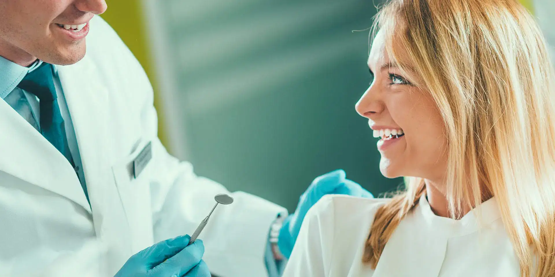 A dentist examining a smiling patient